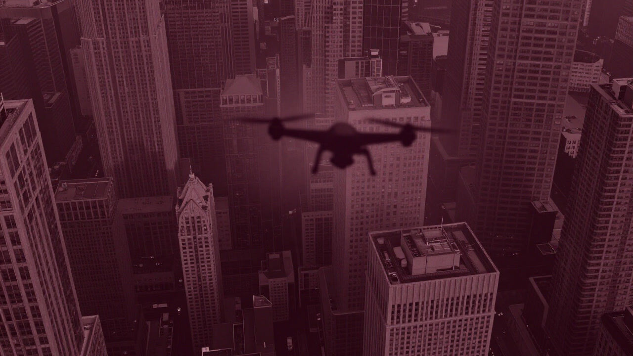 The silhouette of a drone’s wing attempting an overhead view through gaps between skyscrapers