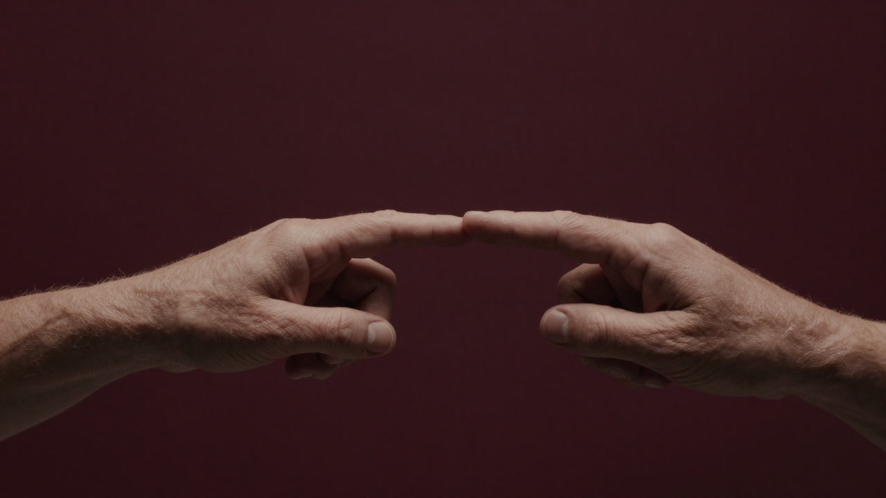 Close-up of a trembling hand offering contact, fingertips lightly touching an open palm