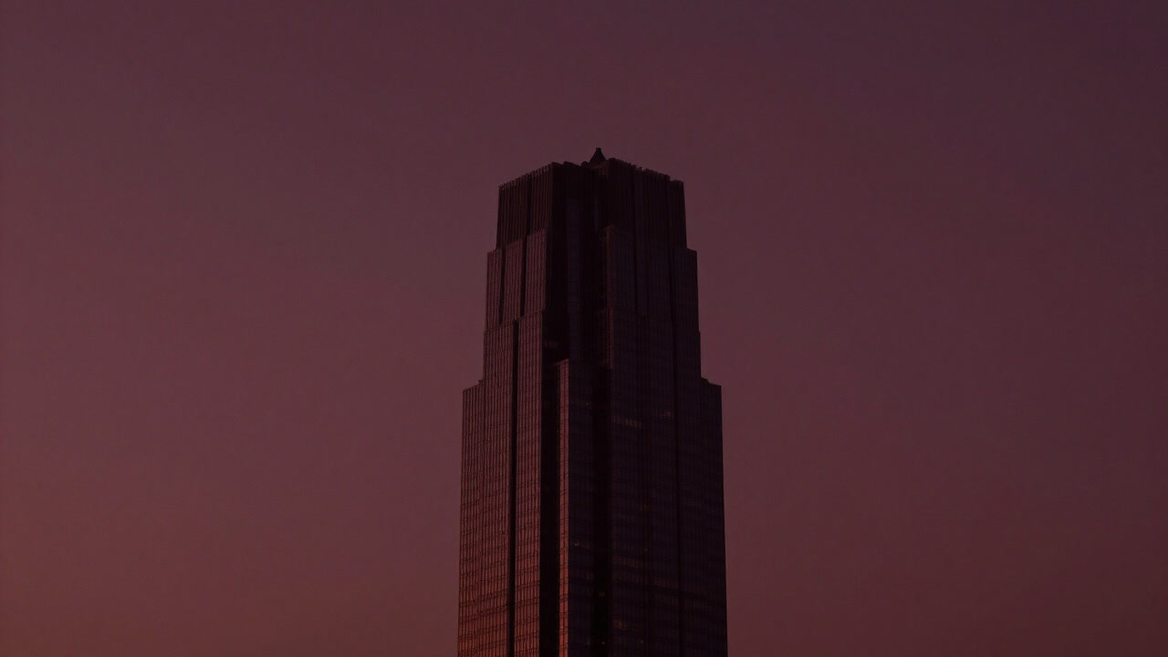 A silhouette of a skyscraper blending into darkness at dusk