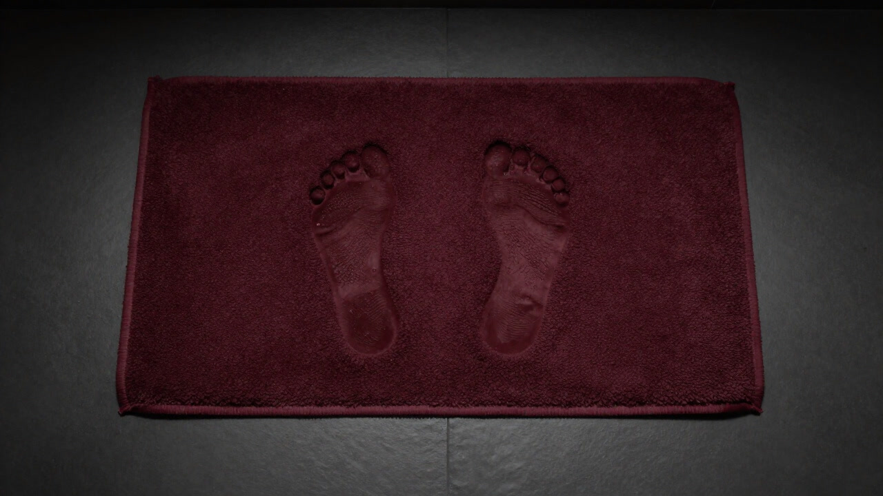 Photo of footprints casually placed on a wet bath mat