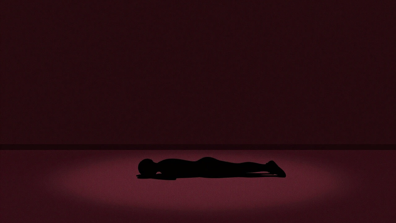 Silhouette of a person doing a plank on the floor with empty gym machines behind