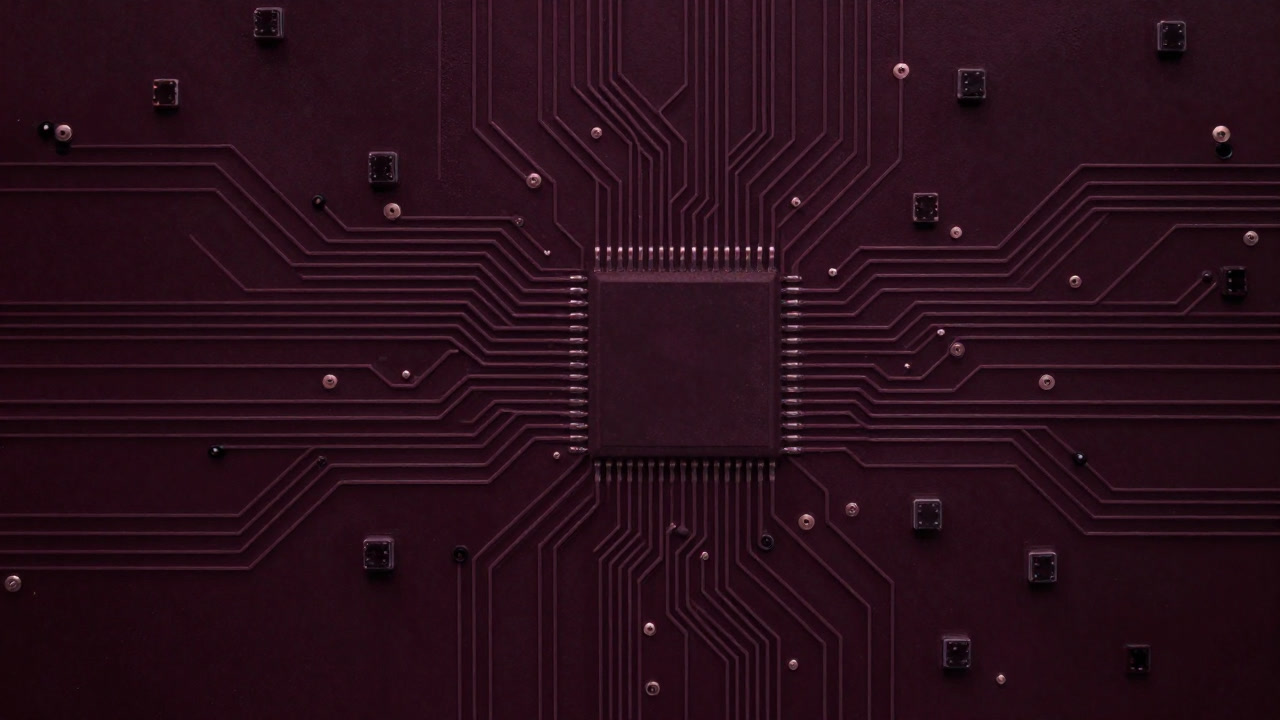 Image of a circuit board scattered with tiny square chiplets entangled in maze-like wiring.