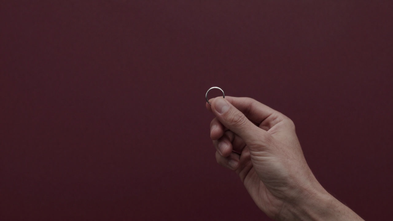 婚約指輪を見つめて震える手元の画像