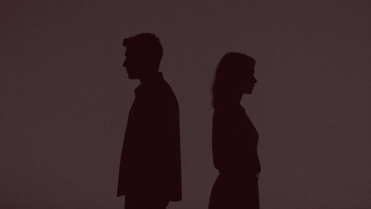 淡い光の中で互いに背を向ける二人のシルエット