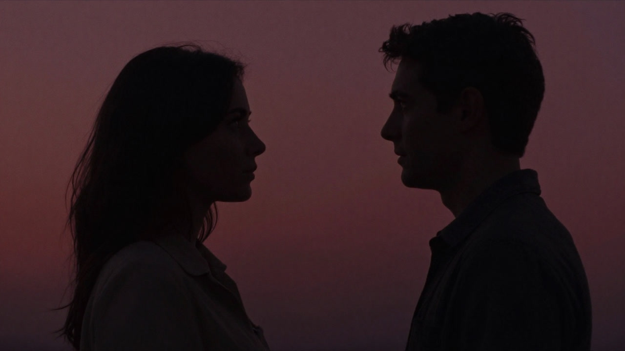 男女が向き合い、互いの視線を交わす瞬間を捉えたシルエットの画像