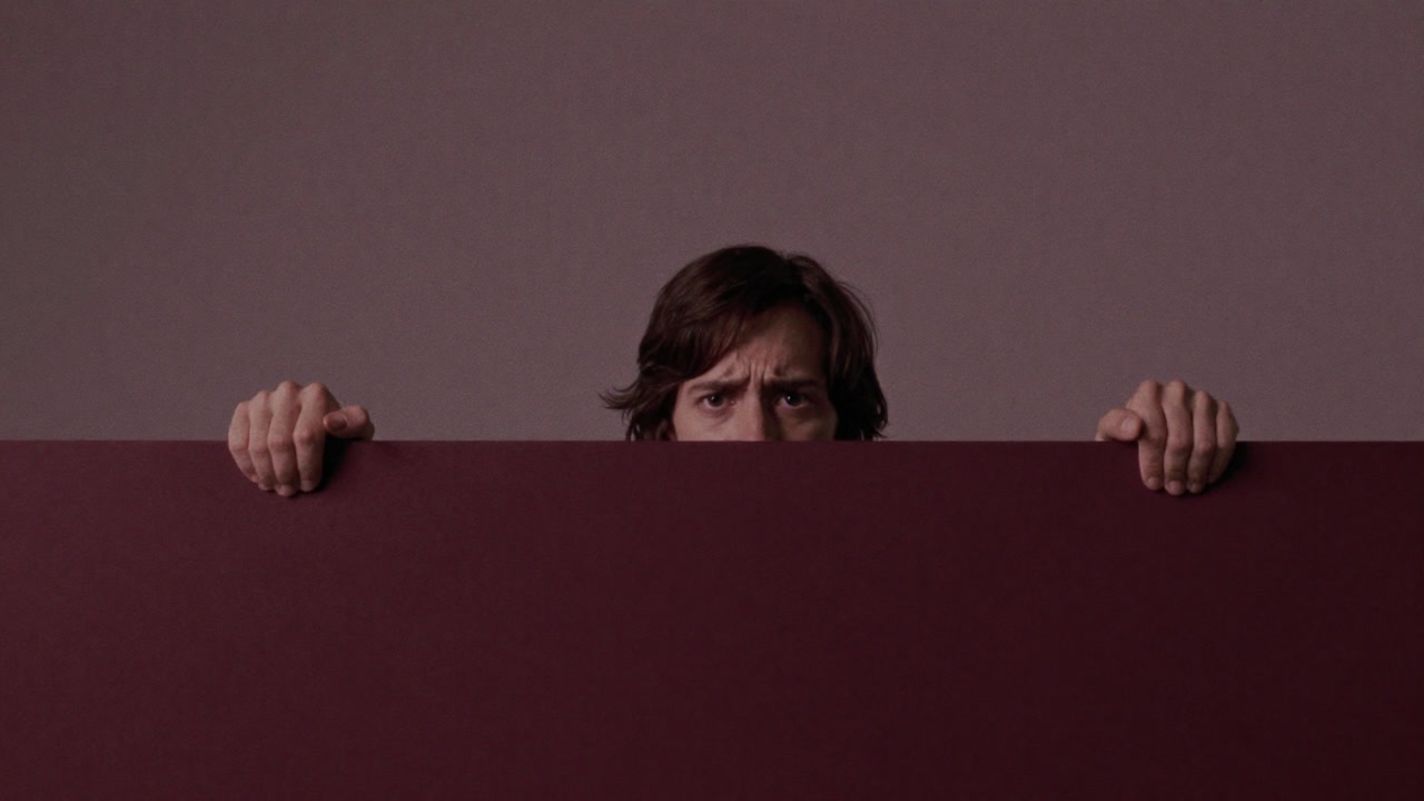 見えない壁に手を伸ばそうとしても届かず、歪んだ表情で拳を握る人のイラスト