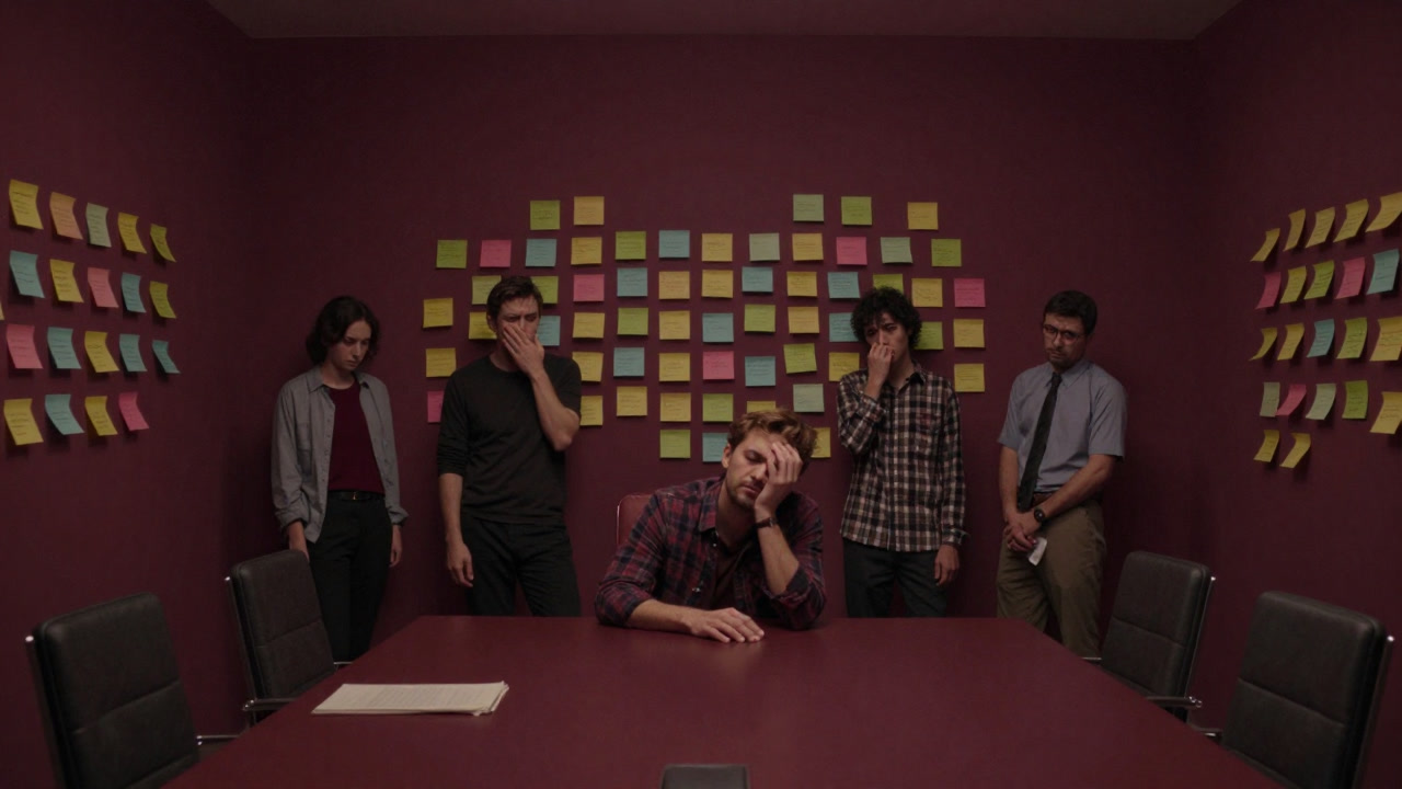 会議室の壁一面に貼られたカラフルな付箋と、遠巻きに佇む疲れたチームメンバーの姿