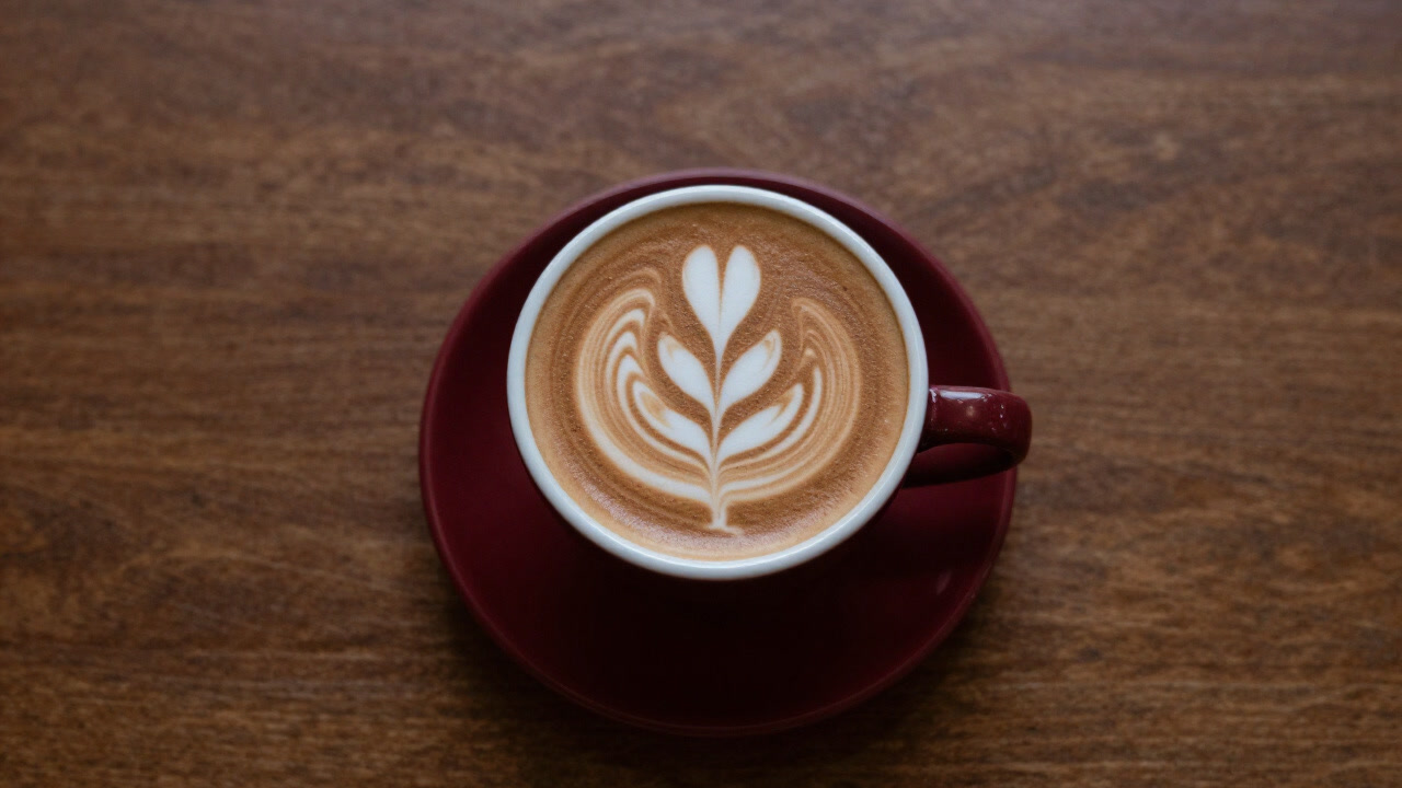 テーブルに置かれたラテのカップを真上から撮影した写真