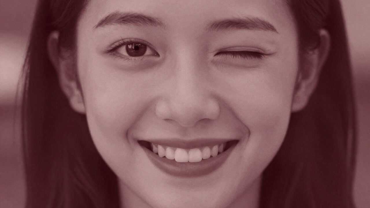 顔の一部だけが大写しされ、ぼかされた背景の中で不自然な笑顔を浮かべるポートレート写真のイメージ