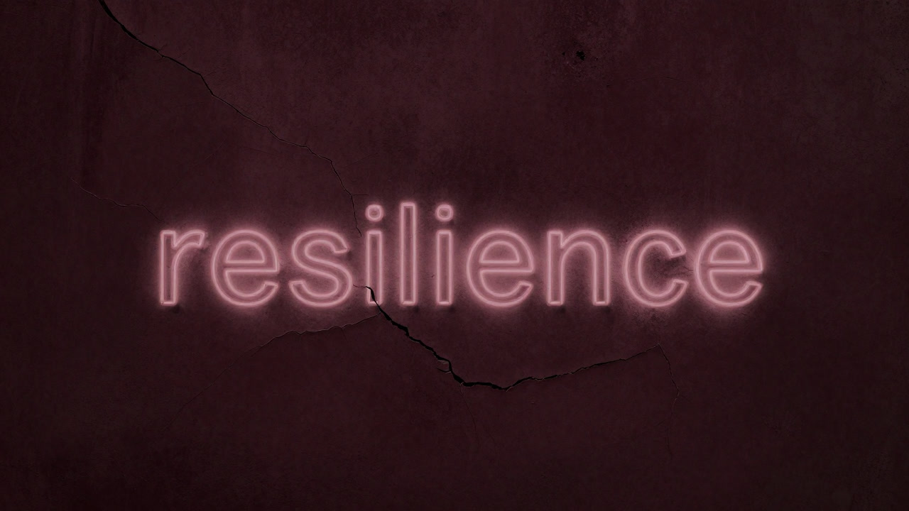 ヒビ割れた壁にかすかに浮き上がる『レジリエンス』という文字の画像