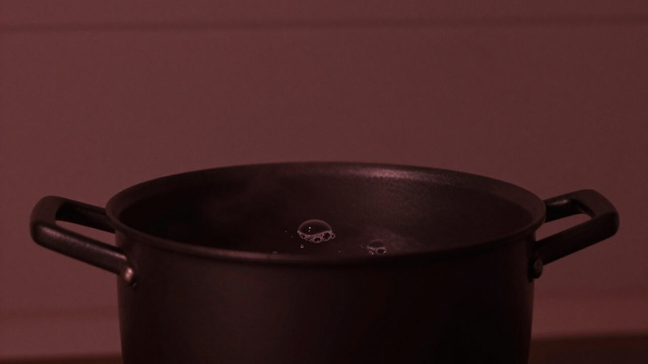 A close-up of a pot with gentle bubbles rising in a simmering stew, capturing a serene moment.