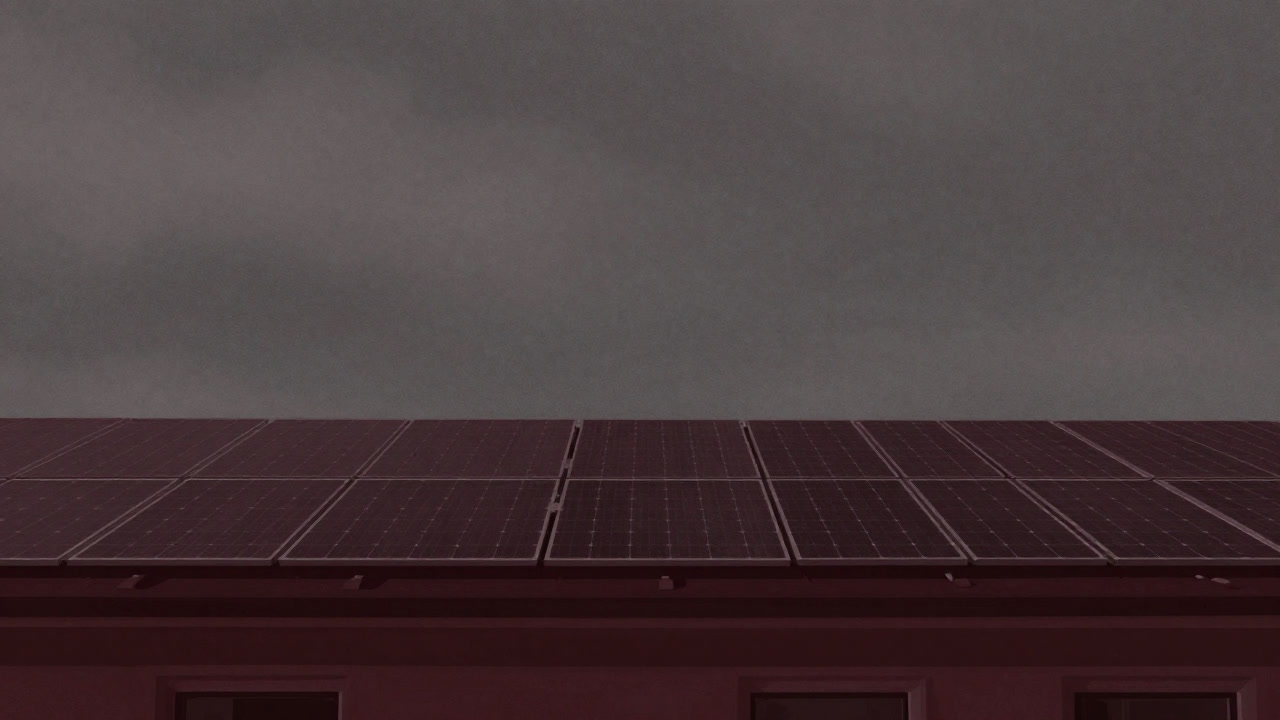 Solar panels installed on a roof shining faintly under a cloudy sky