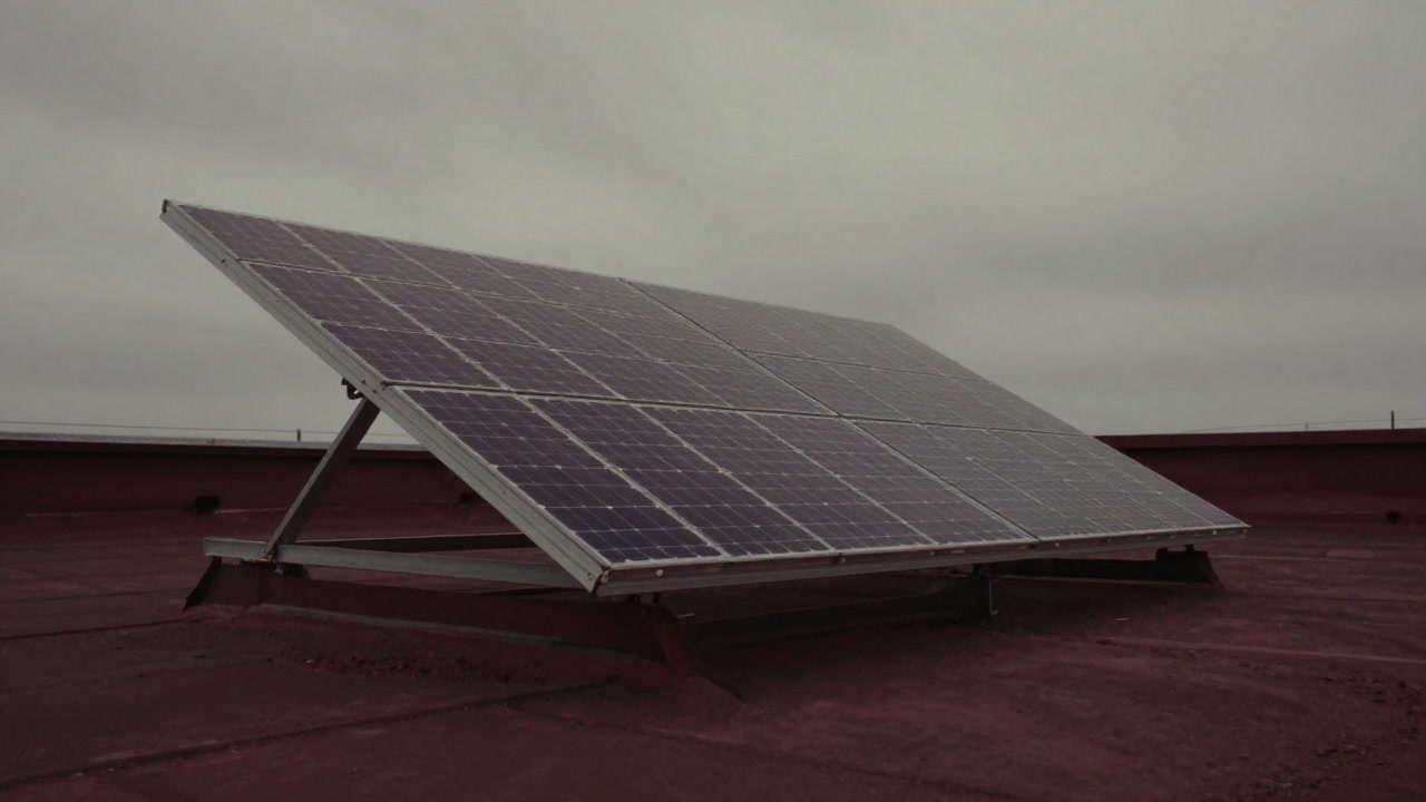 A silver parabolic trough under a cloudy sky, reflecting light futilely