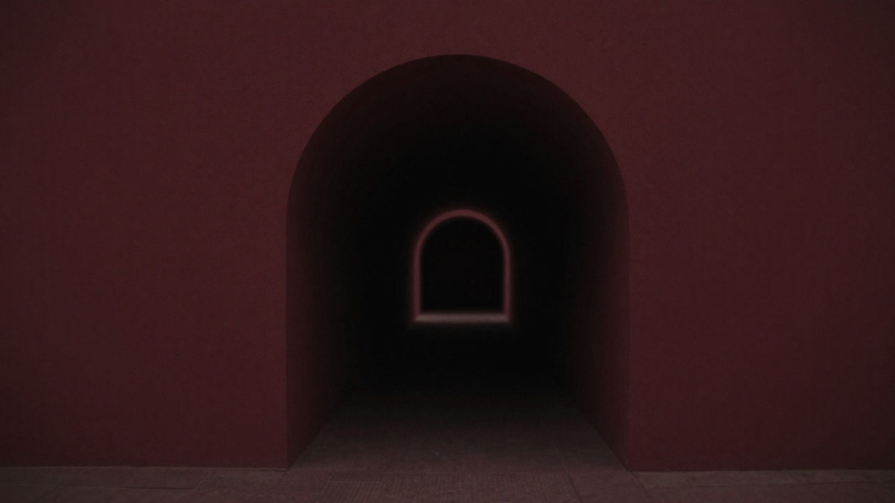 暗いトンネルの入口が遠近感を強調して延びる様子を捉えた写真