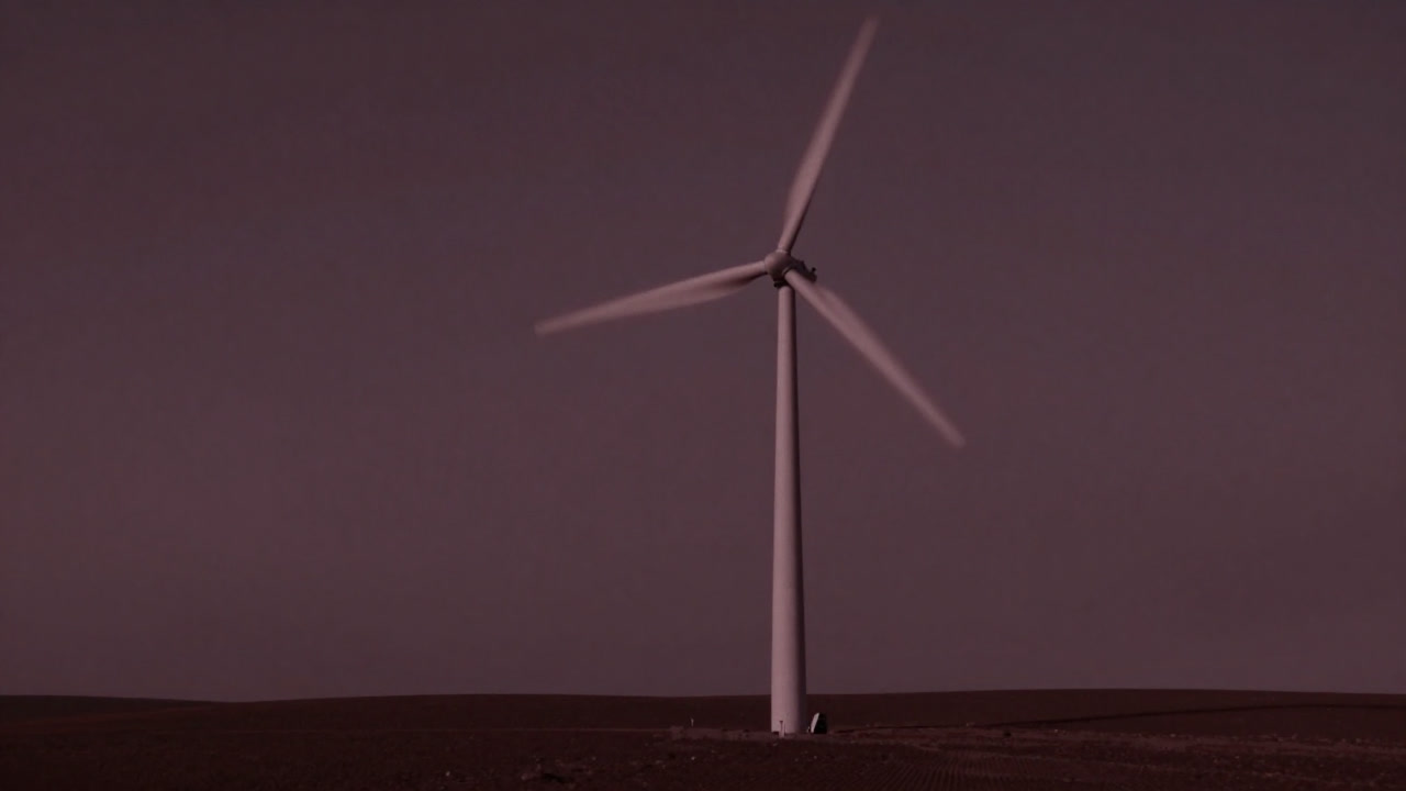 巨大な風力タービンが風を求めて空を仰ぐシルエット